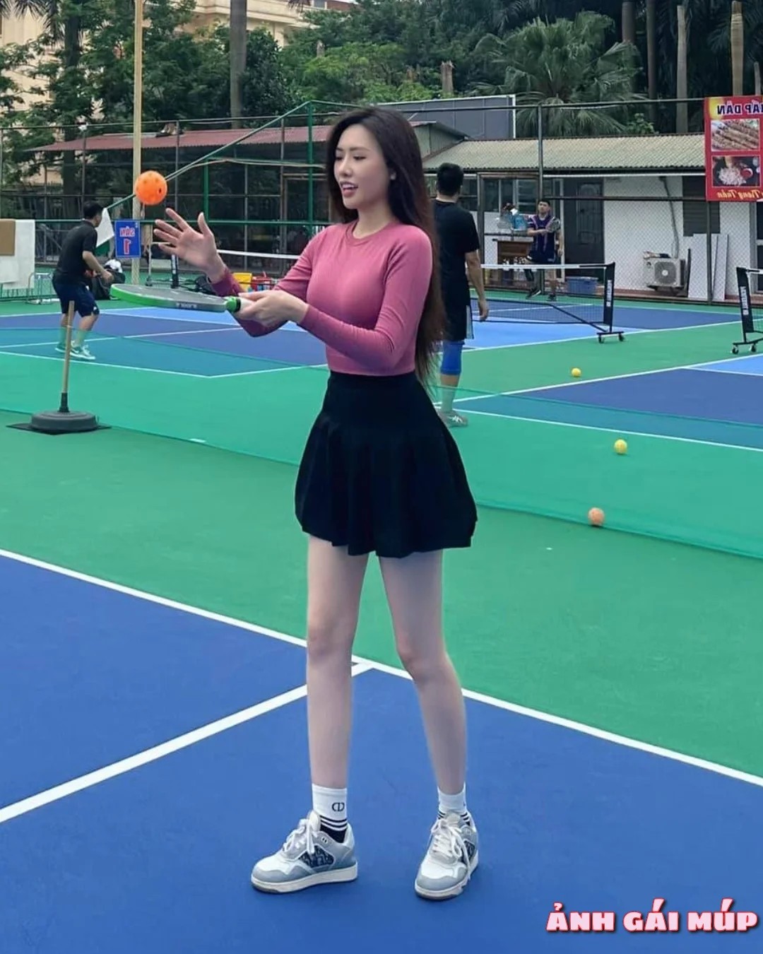Cô gái chơi pickleball với thiết bị nhiếp ảnh chuyên nghiệp