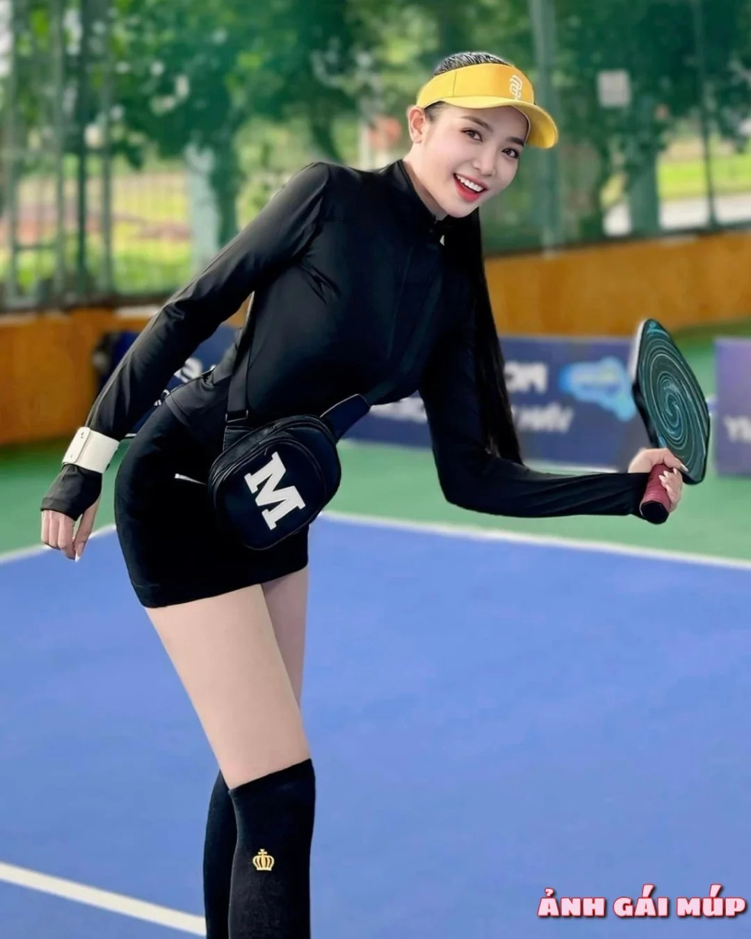 Cô gái chơi pickleball với tư thế chạy đuổi bóng